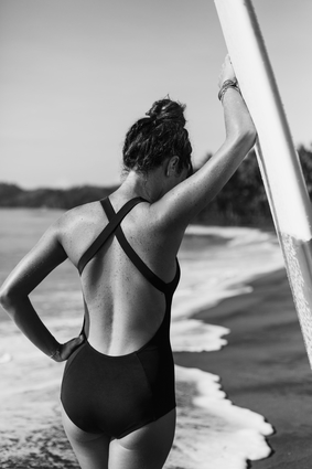Woman With Surfboard By The Ocean